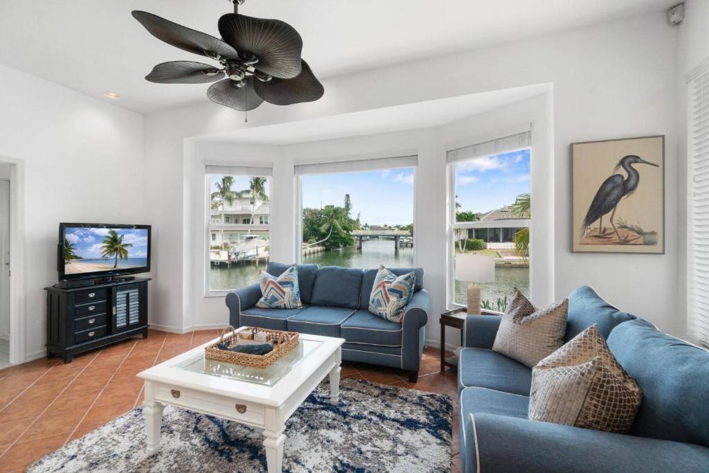 a living room with blue couches and a tv at Manatee Manor in Marco Island