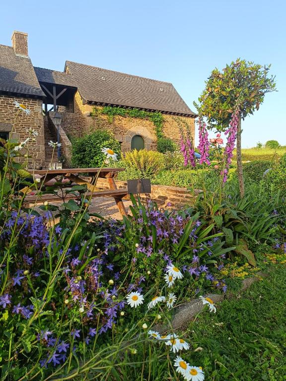 a garden with flowers in front of a building at La Valaisienne in Val Couesnon