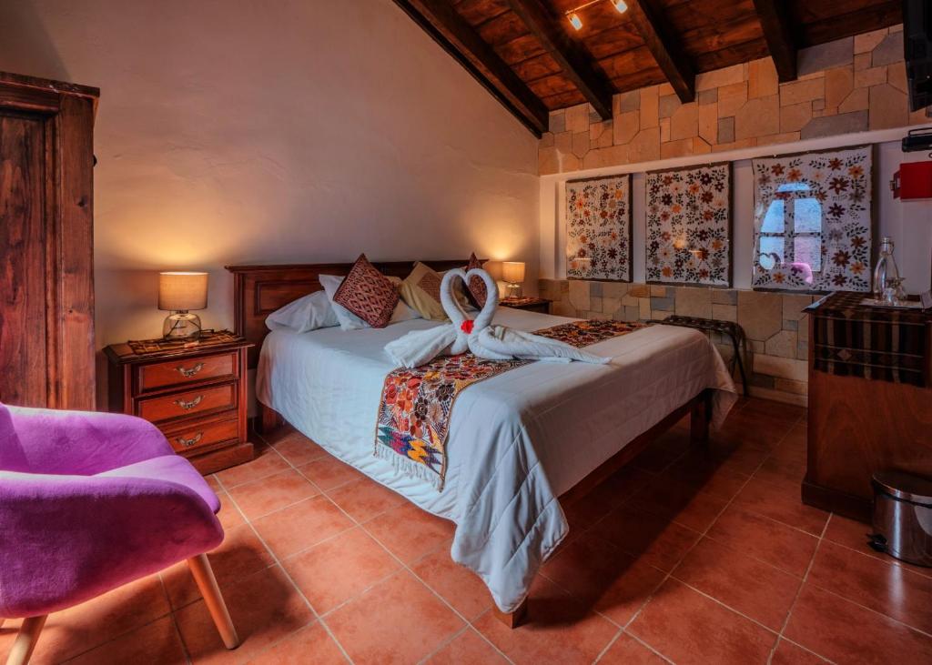 a bedroom with two beds and a purple chair at Hotel Tepeyac in San Cristóbal de Las Casas