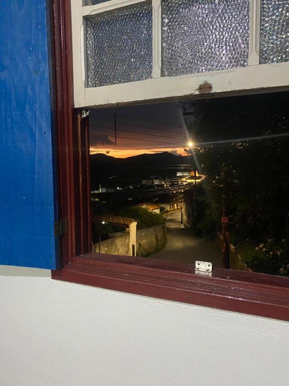 a view of a sunset through a window at Kitnet Imperial in Ouro Preto