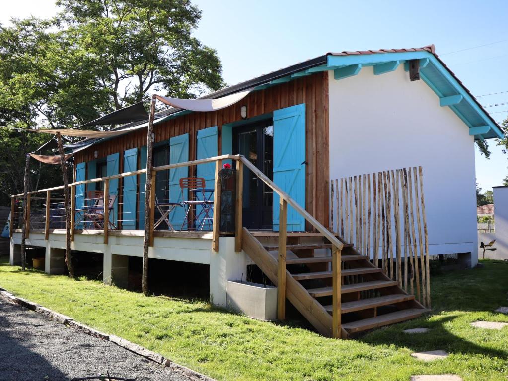 a small house with a blue door and a porch at Les Pignottes in Gujan-Mestras