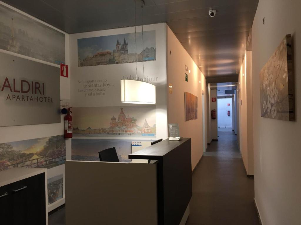 um escritório com um corredor com uma secretária e uma parede em Apartahotel Baldiri em Sant Boi del Llobregat