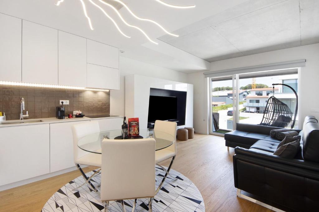 a kitchen and living room with a table and a couch at Uno del Mar 2 in Vila Nova de Gaia
