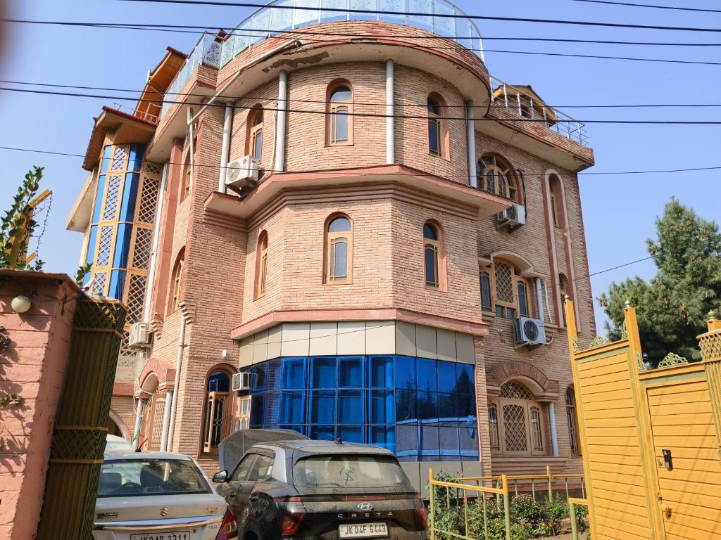 ein Gebäude, vor dem Autos parken in der Unterkunft Bashaw Residency Top Rated In Srinagar Only 6 Kms from Srinagar International Airport And Only 5 Kms From Srinagar Railway Station in Srinagar