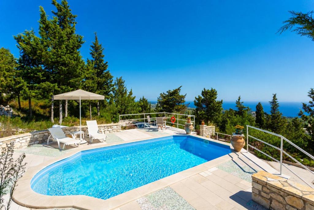 a swimming pool in a backyard with a patio at Villa Windmill in Vlachopoulátika