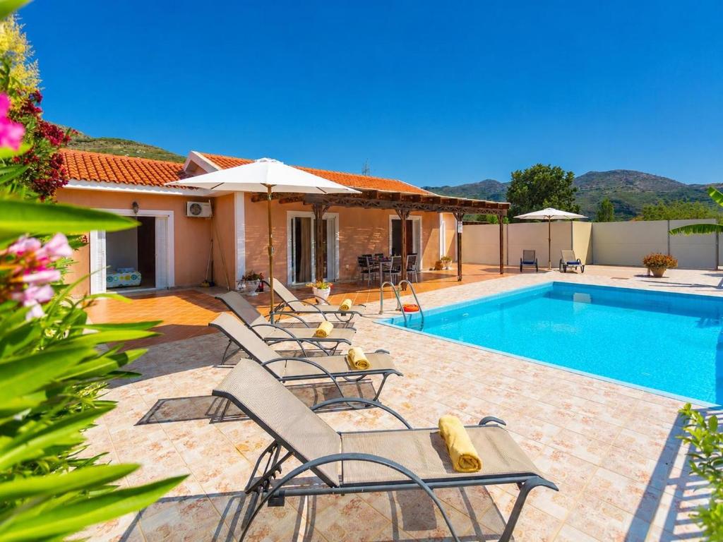 a villa with a swimming pool and a house at Villa Peach in Katelios
