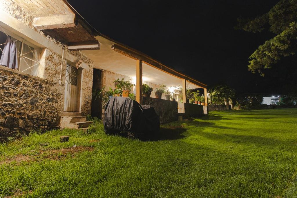 a house with a blanket on the grass next to it at Hospedaje Las Palmas By GEstores in Huasca de Ocampo