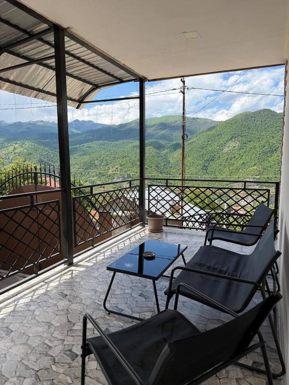 a balcony with chairs and a table and a view at DiliOne Guest House in Dilijan