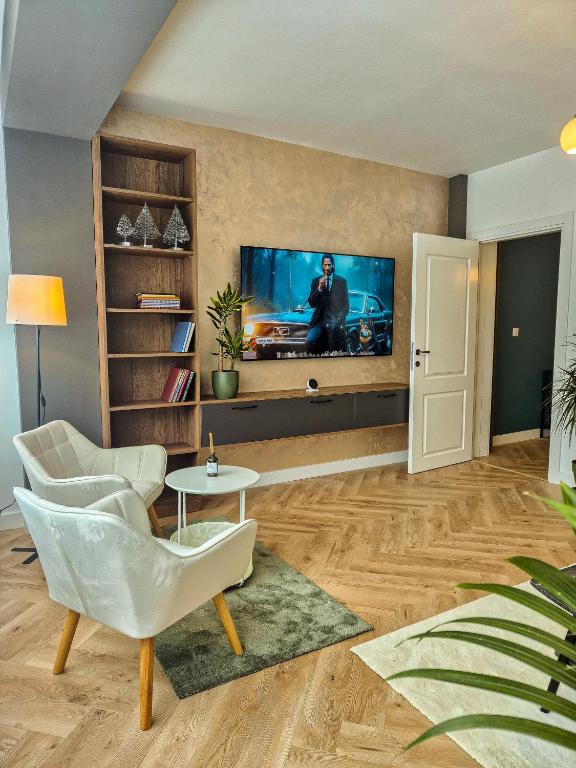 a living room with a tv on a wall at Boutique Apartment Suceava Modern Parcare WiFi Rapid in Ipoteşti