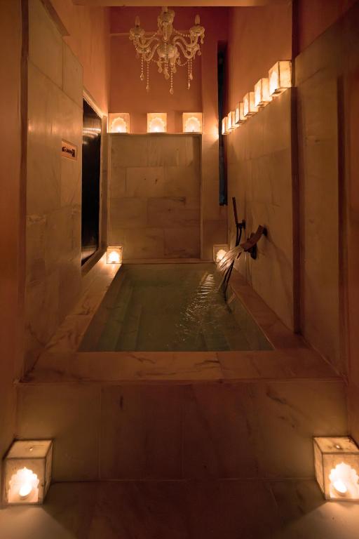 a bath tub in a room with a chandelier at Misty BNB And Homestay in Jaipur