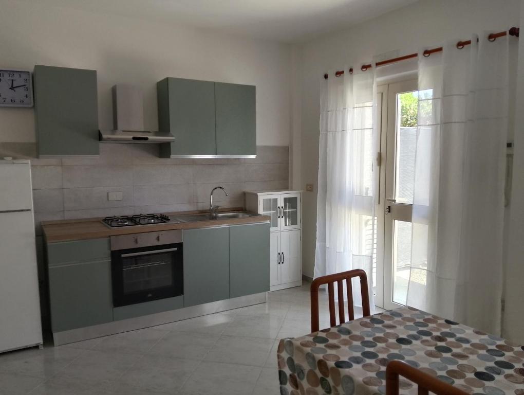a kitchen with green cabinets and a table and a window at Casa Amica Termoli 1 in Termoli