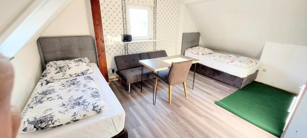 a small room with two beds and a table at FMI 9 Accommodation in Raunheim