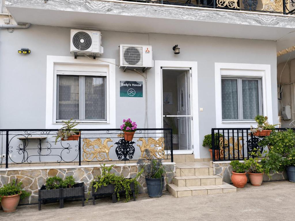 a white house with potted plants in front of it at Sady's House in Yimnón