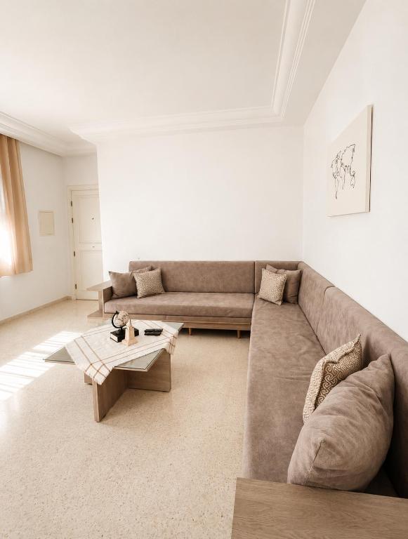 a living room with a couch and a coffee table at Chic & Comfortable Stay in Monastir