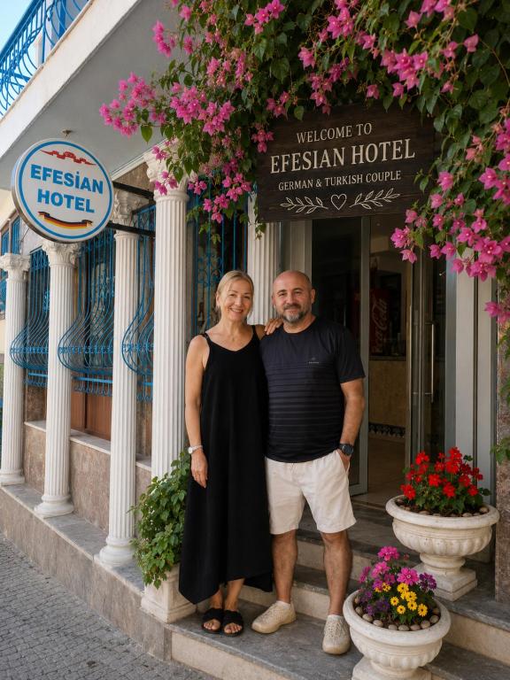 a man and woman standing in front of a hotel at Hotel Efesian B&B City Center - Harbour in Kuşadası