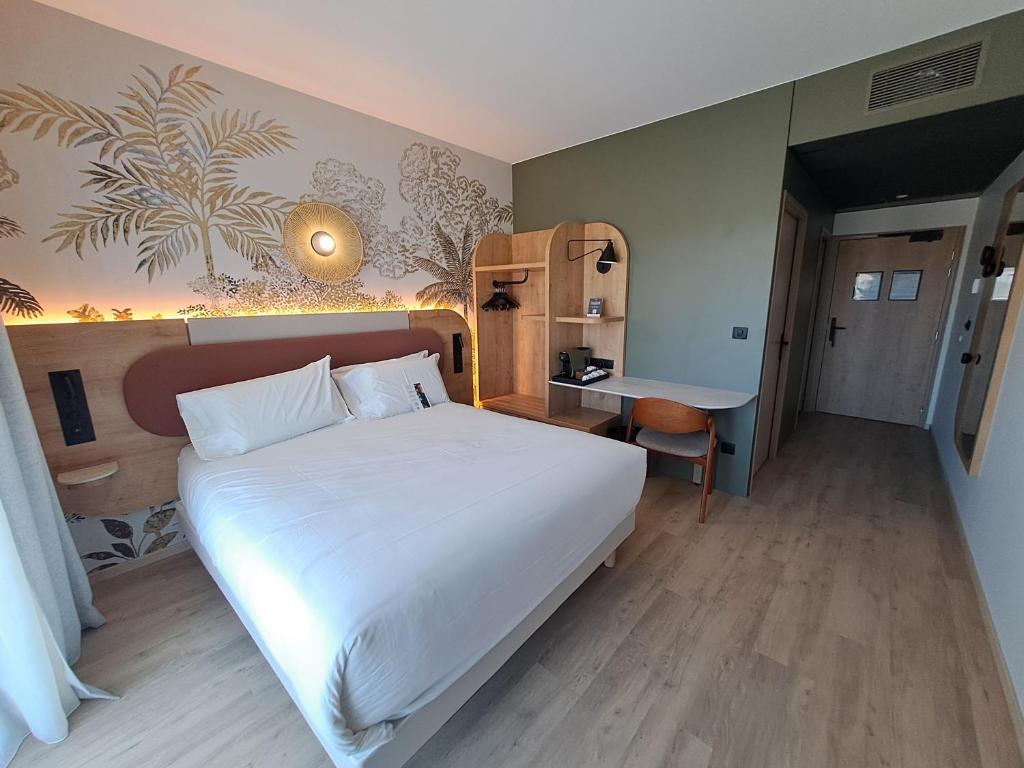 a bedroom with a large white bed and a desk at KYRIAD PRESTIGE - PIERRELATTE in Pierrelatte