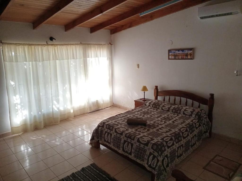 a bedroom with a bed and a large window at Hospedaje Nely in San Vicente