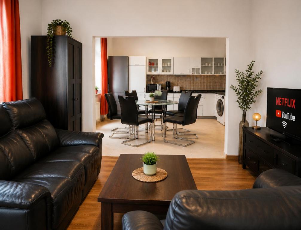 a living room with a leather couch and a table at 110m2 Old Town Apartment on Danube Promenade 3BR 2BA Up to 9 Guests in Bratislava