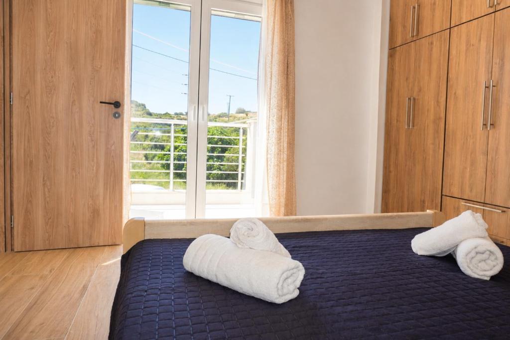 a bedroom with towels on a bed with a window at Karies House in Kefalos