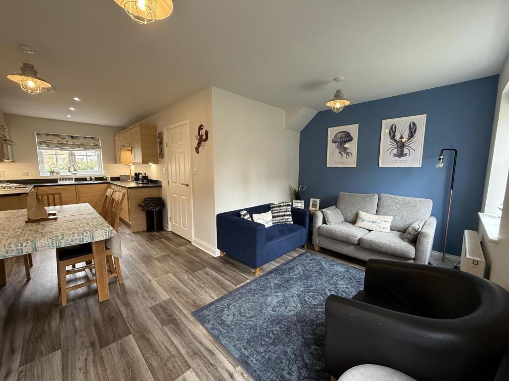 a living room with a couch and a table at Sea Esta, The Bay, 2 bedrooms, patio garden, parking nearby, 2 dogs welcome in Filey