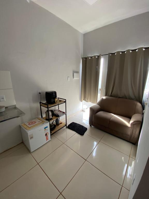 a living room with a couch sitting on a tiled floor at Flat aconchegante é silencioso in Rio Verde