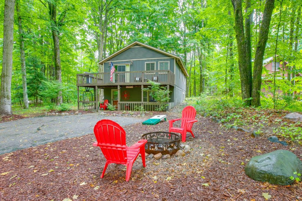 a house with three red chairs in front of it at Crystal Mountain Resort Cabin: Golf, Hike, Swim! in Thompsonville