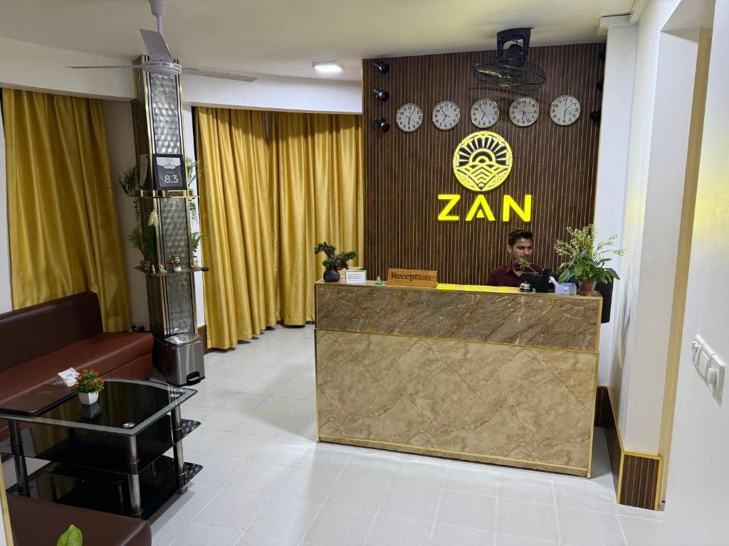 a man sitting at a reception desk in a room at ZAN Lodge in Male City