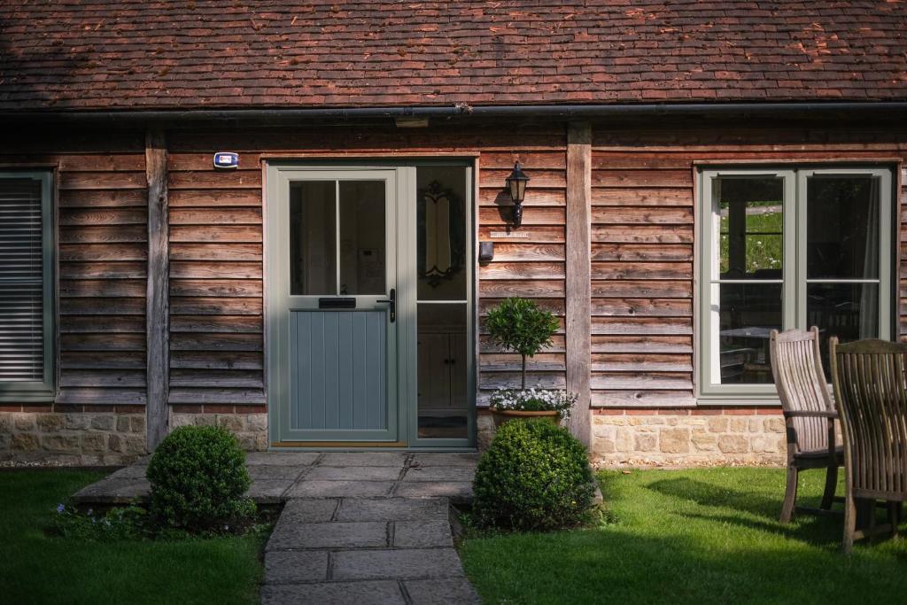 a wooden house with a door and a window at Oaters Wood in Petworth