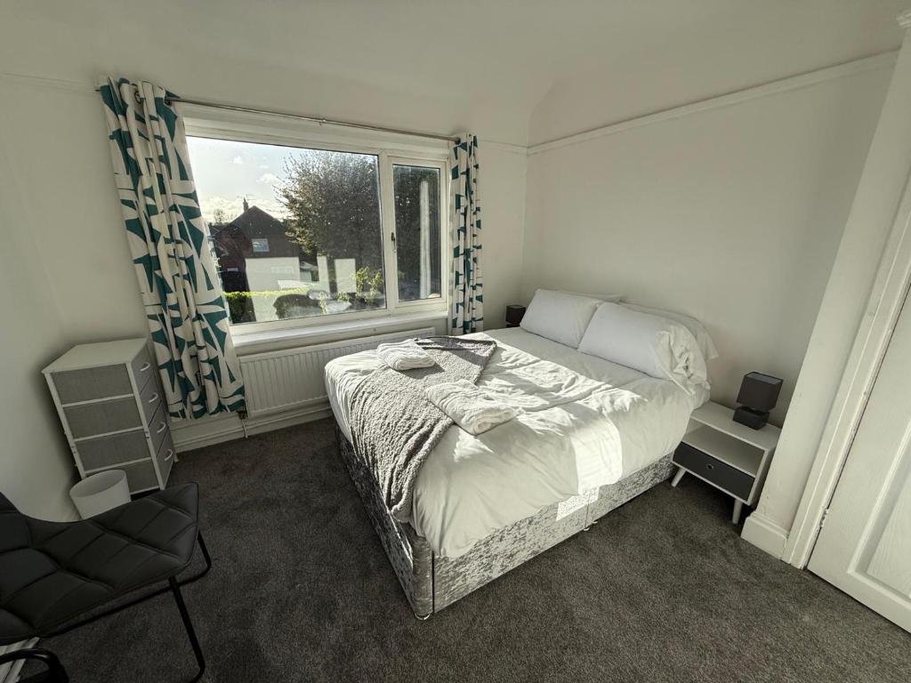 a bedroom with a bed and a window at Short Stay & Long Stay home in Ellesmere Port in Little Sutton