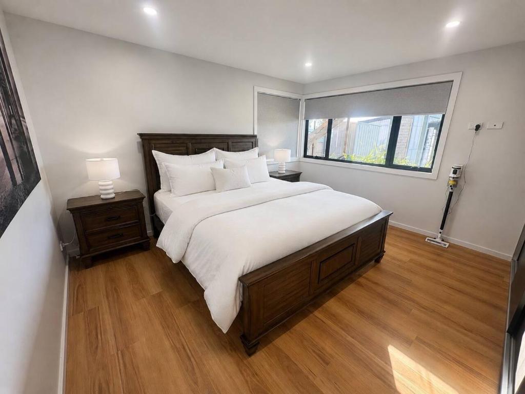 a bedroom with a large bed and a window at Derwent Waters Hideway in Austins Ferry