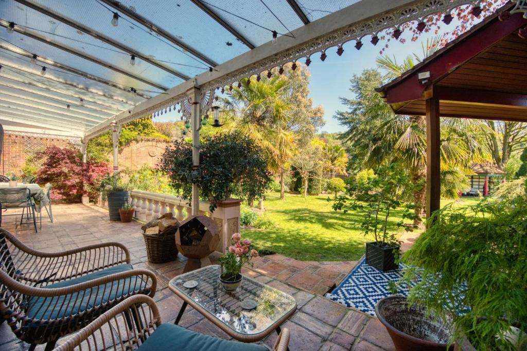 a patio with chairs and a table and a fireplace at Hillsley House in Wirksworth