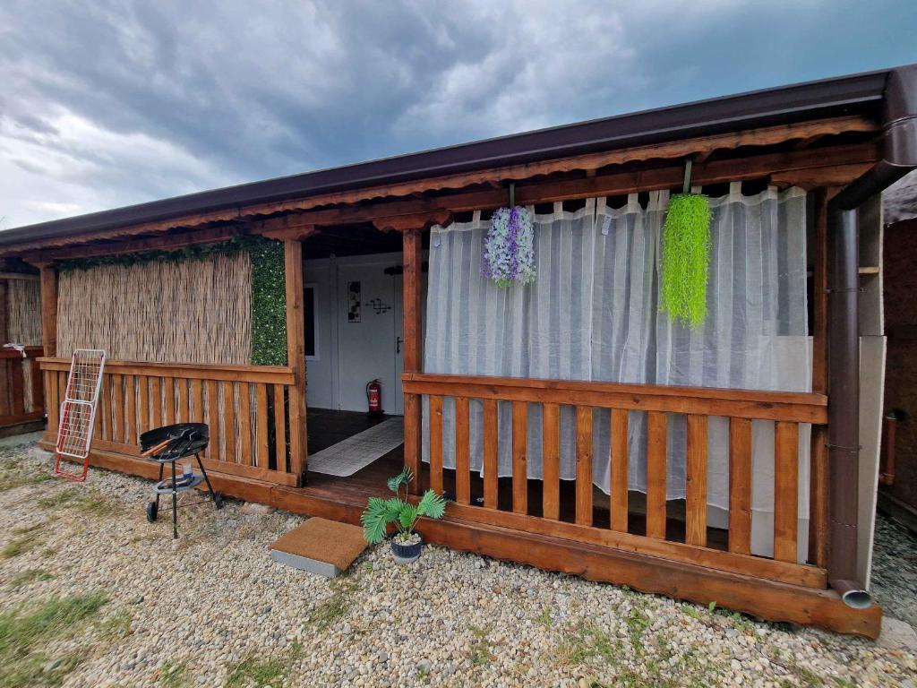 a wooden cabin with a porch and a chair at Bungalows Rea in Burgas