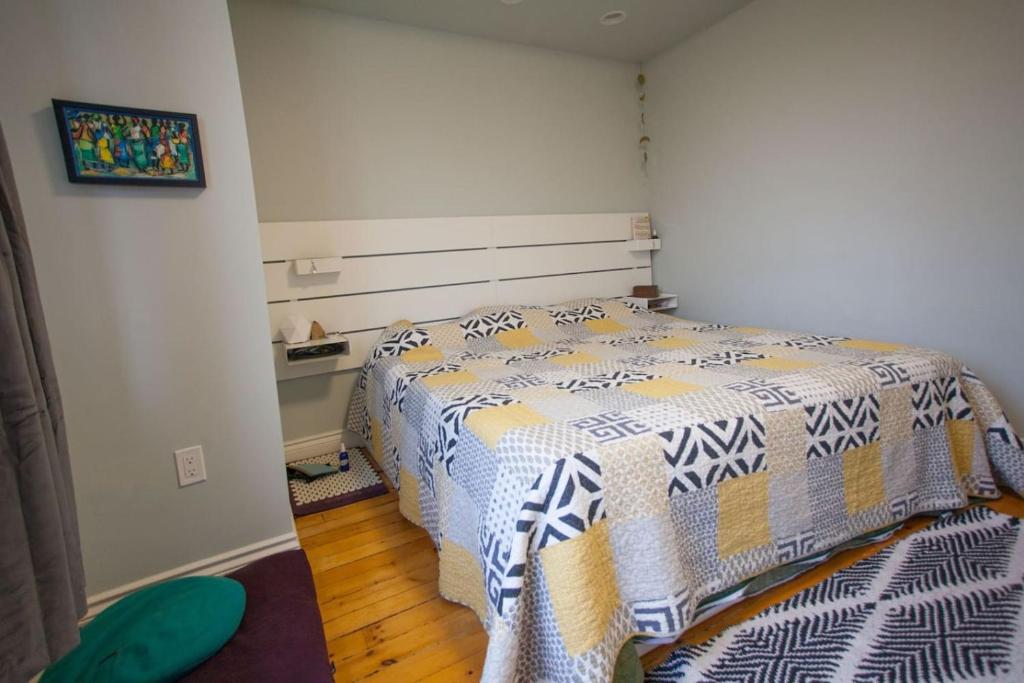 a bedroom with a bed with a comforter on it at Location Location Location in Stratford