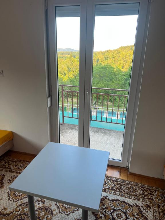 a white table in front of a sliding glass door at Jagoda IN in Otroci
