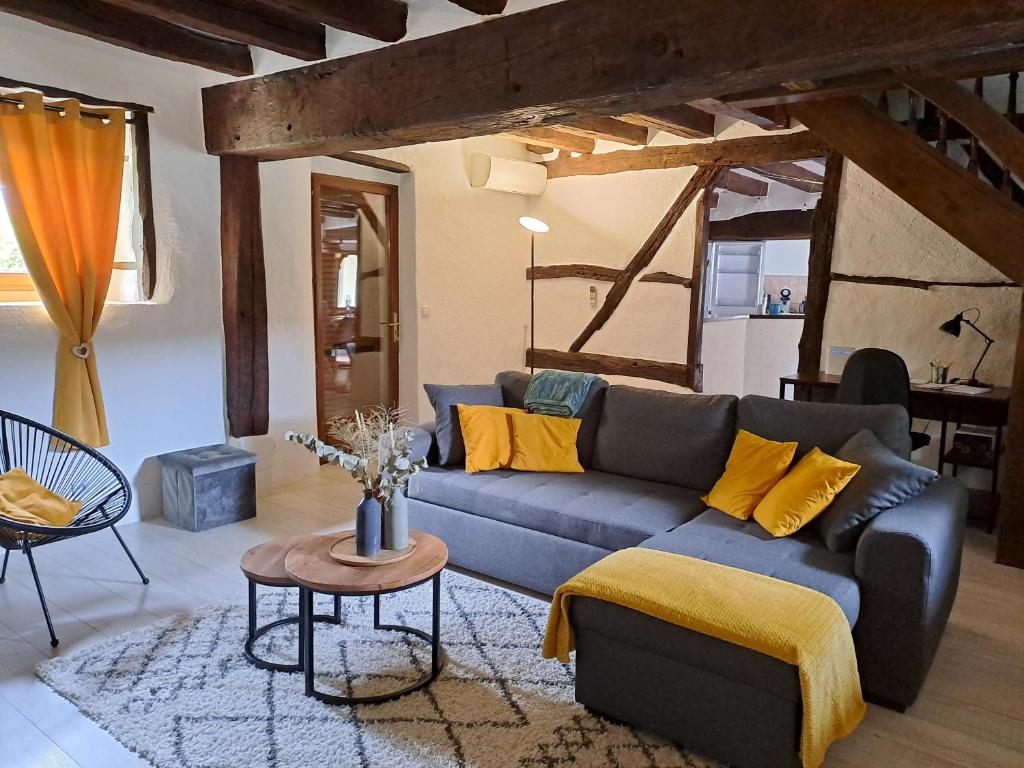 a living room with a blue couch and yellow pillows at La Chaumière de Chabine in Oizon
