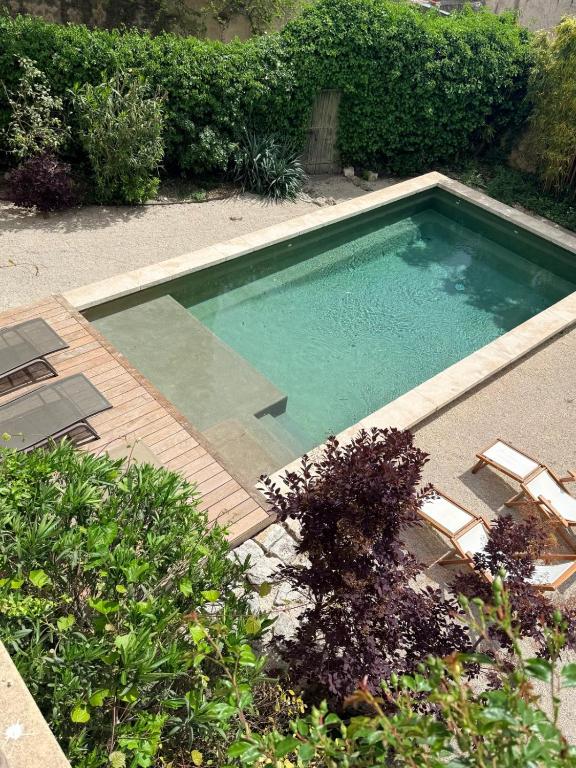 a swimming pool with two chairs at La Brèche - Mansion with swimming pool in Velleron