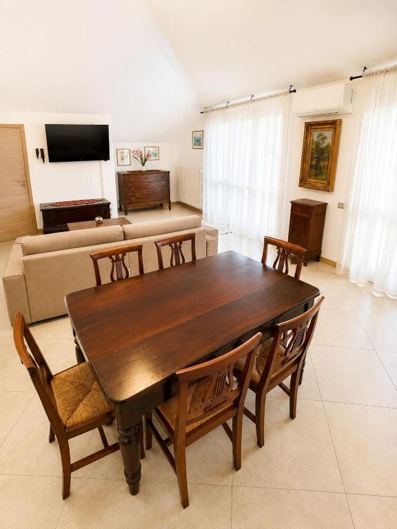 a living room with a wooden table and chairs at il canto del lago in Iseo