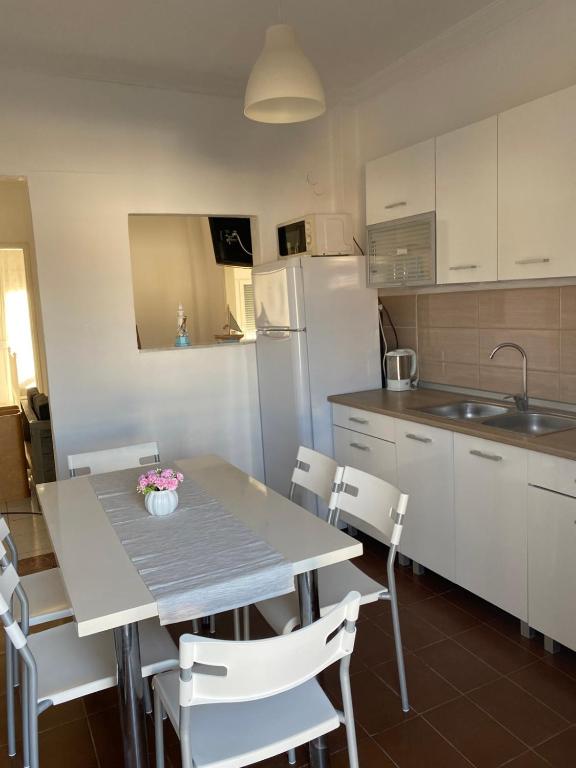 a kitchen with a table and chairs and a refrigerator at Georgia's House Olympiada in Olympiada