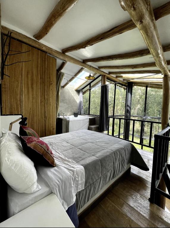 a bedroom with a bed in a room with windows at Aldealma in Pisac