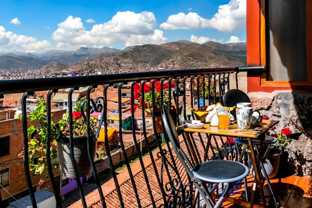a balcony with a table and chairs and a view of a city at El Balcón del Sol - Dpto Céntrico con Vistas Perfectas in Cusco