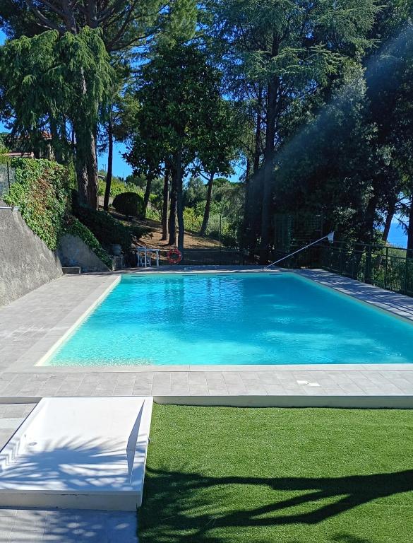 a swimming pool in a yard with grass and trees at Le Mimose Garden in Bordighera