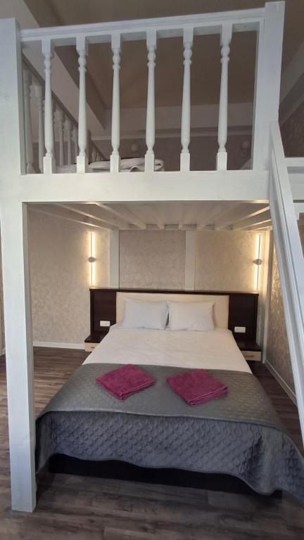a loft bed with two red pillows on it at Vinnytsia City Center Guest House in Vinnytsya