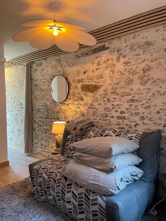 a bedroom with a bed and a stone wall at Studio de caractère en pierre in Coutances