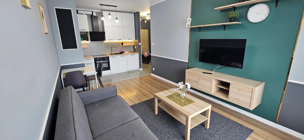 a living room with a couch and a tv and a table at Andersena 43 Ząbki in Ząbki