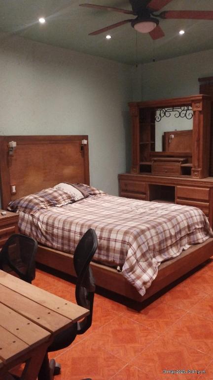 a bedroom with a bed and a mirror and a table at Cómodo departamento equipado in Chihuahua