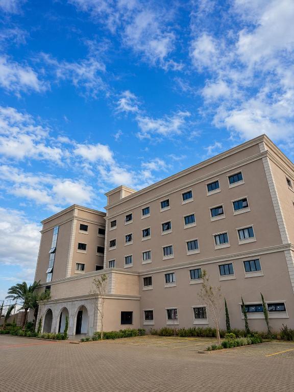 a large white building with a sky in the background at Class Hotel Americana in Americana