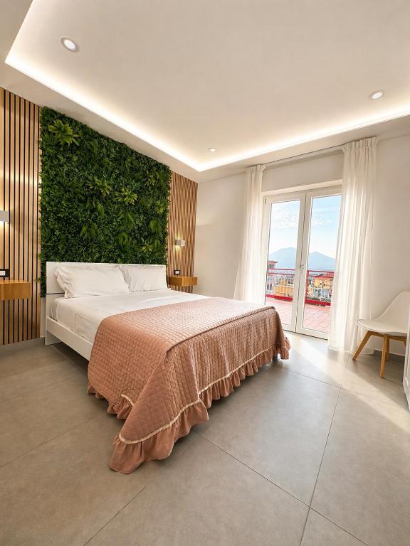 a bedroom with a large bed with a green wall at B&B CaMa in Gragnano