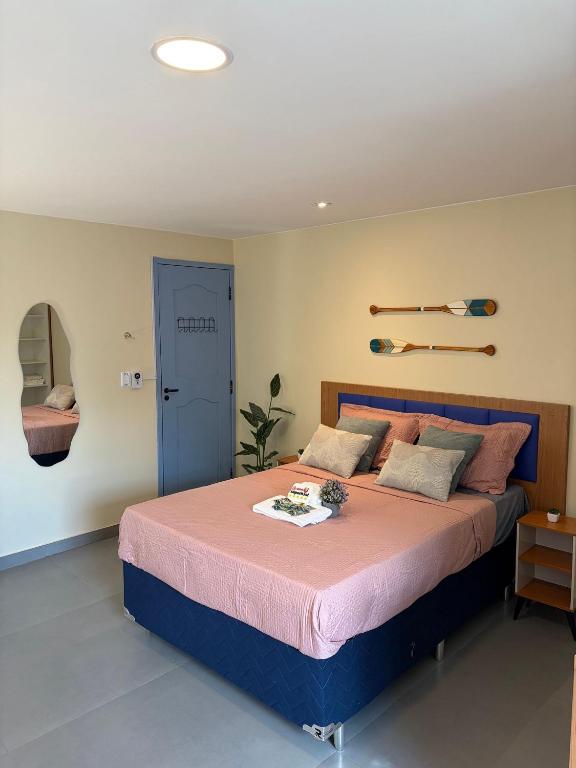 a bedroom with a large bed with a pink blanket at Studios Caripunas Reformado Localização Central in Belém