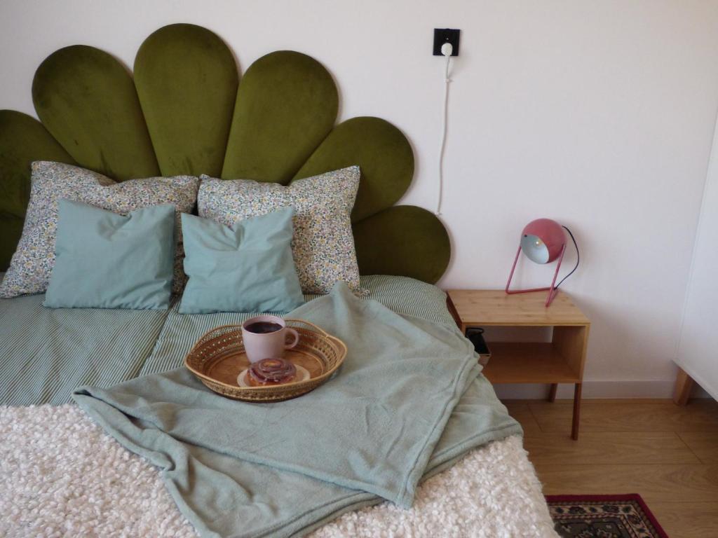 a bed with a tray with a cup of coffee on it at Kwiat Paproci Design Apartment Gdynia in Gdynia