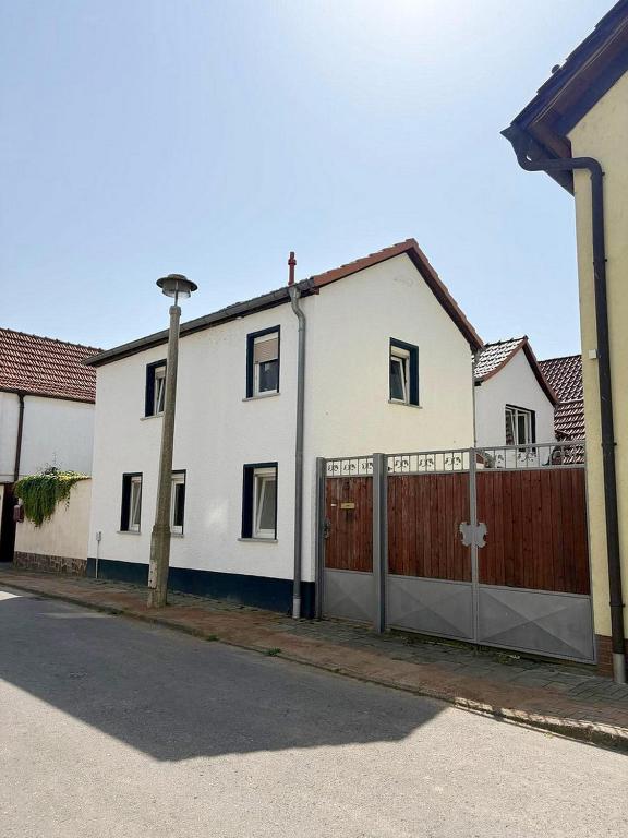 a white house with a gate and a fence at Wohnhaus mit besonderer Ausstrahlung in Bad Frankenhausen